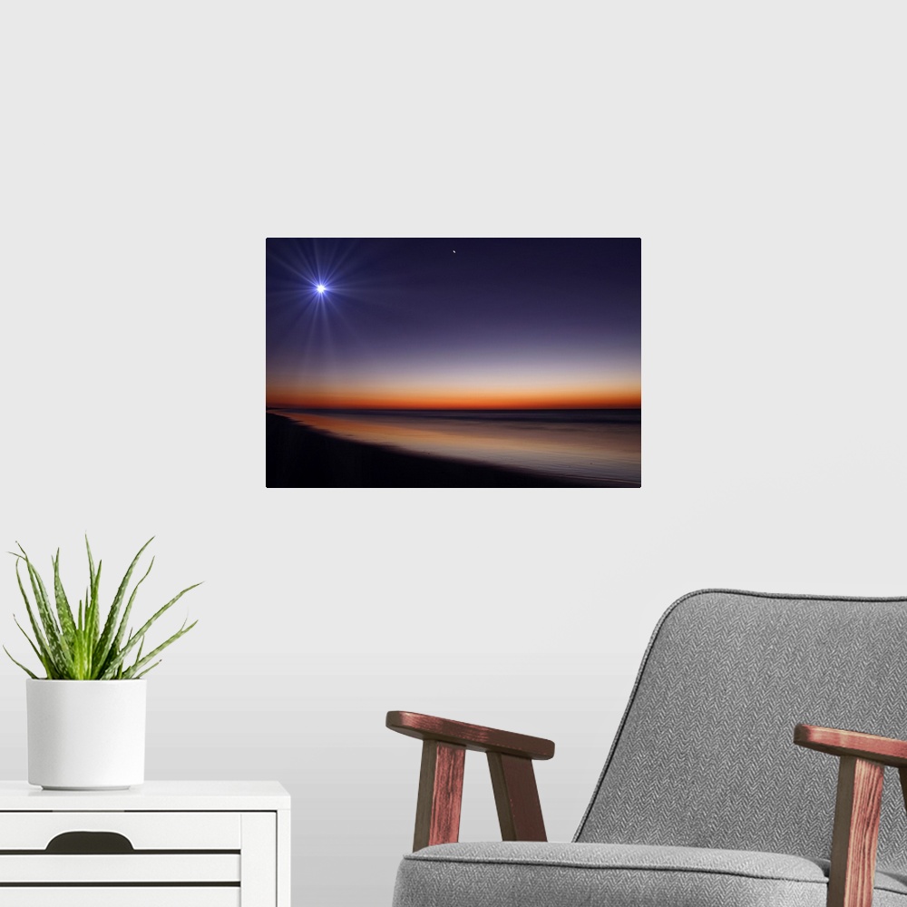 A modern room featuring Big photo on canvas of a bright moon and Venus in the dusk sky above an ocean.
