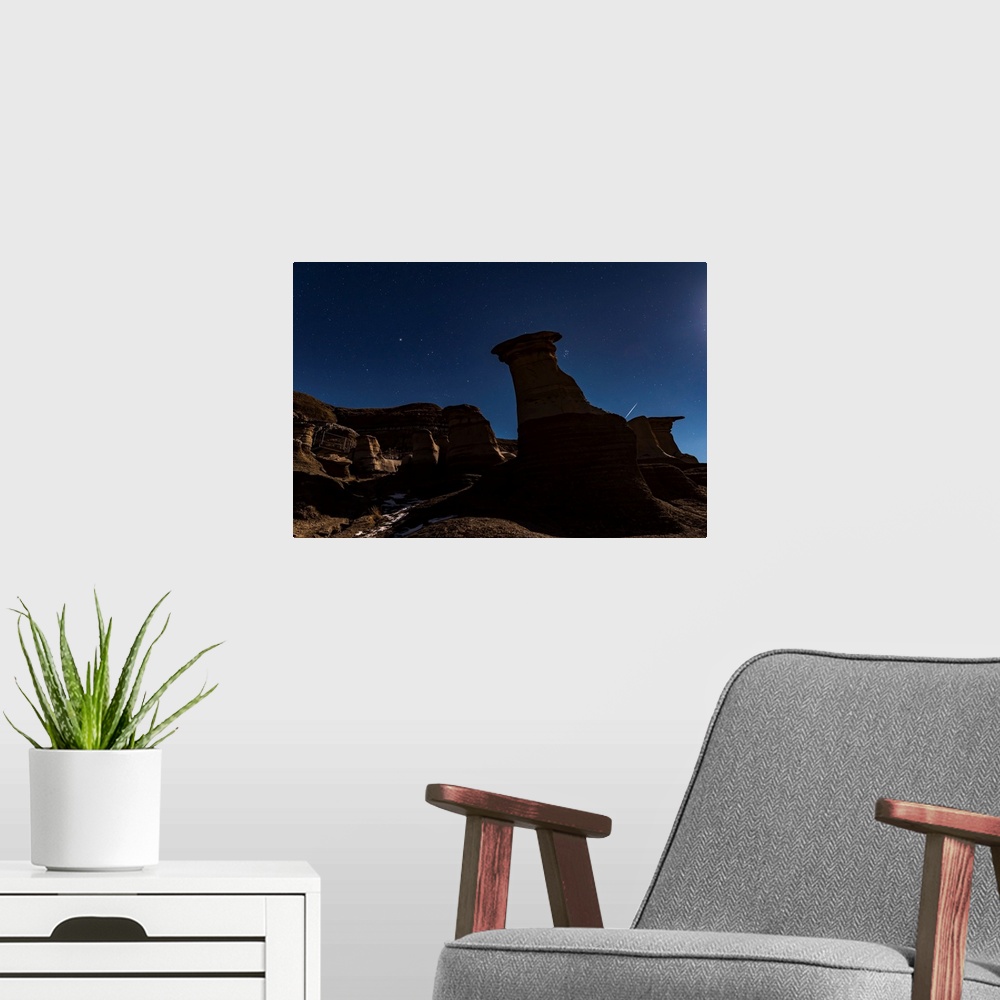 A modern room featuring The Pleiades appearing from behind the Hoodoos in silhouette.