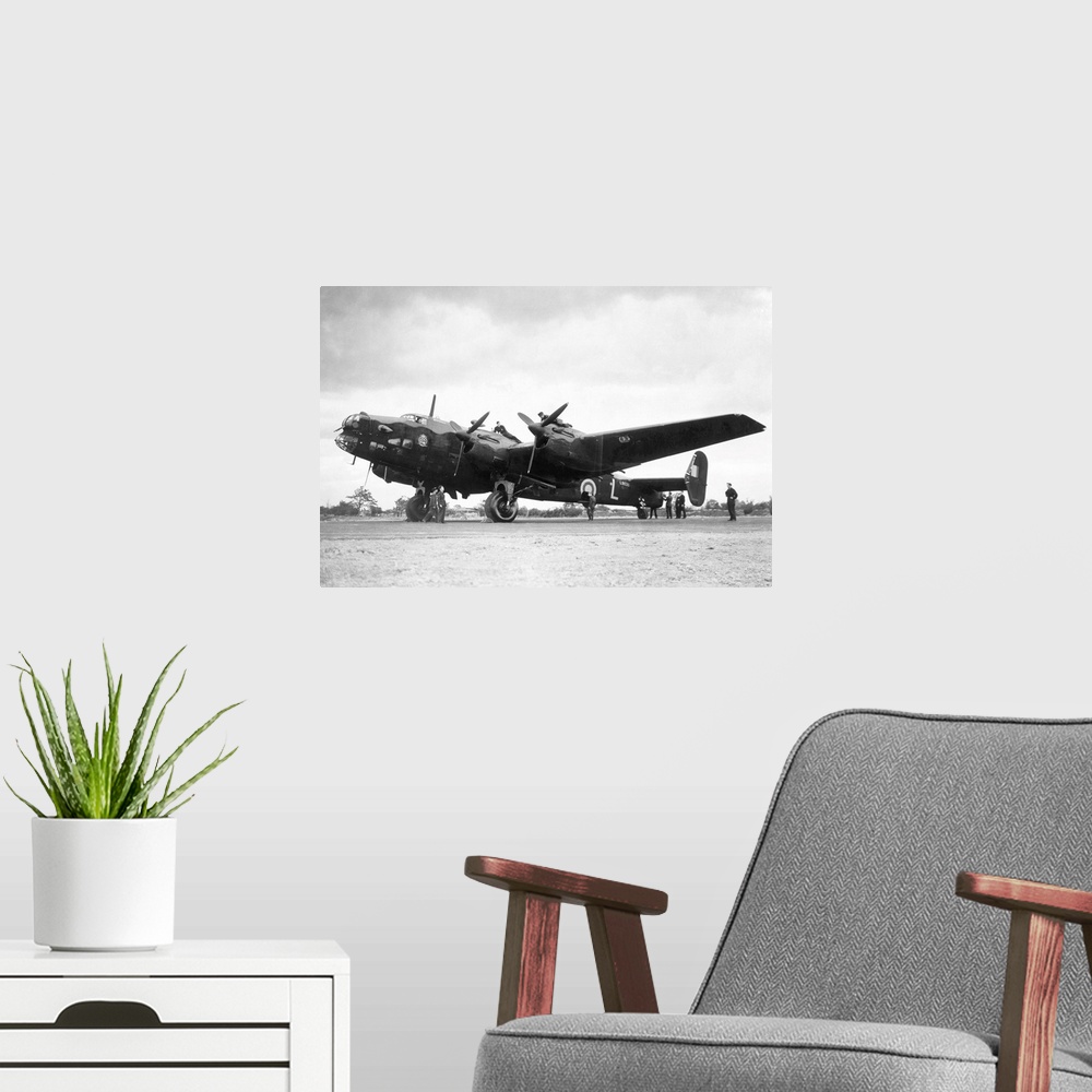 A modern room featuring Crew members service a Handley Page Halifax bomber plane of the British Royal Air Force.