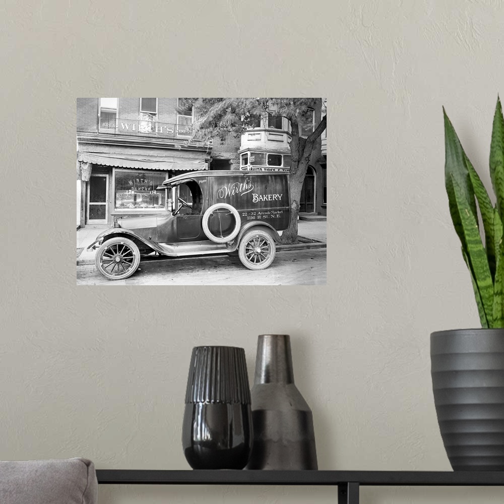 A modern room featuring A car with an advertisement for Wirth's Bakery in front of the store on H Street in Washington, D...