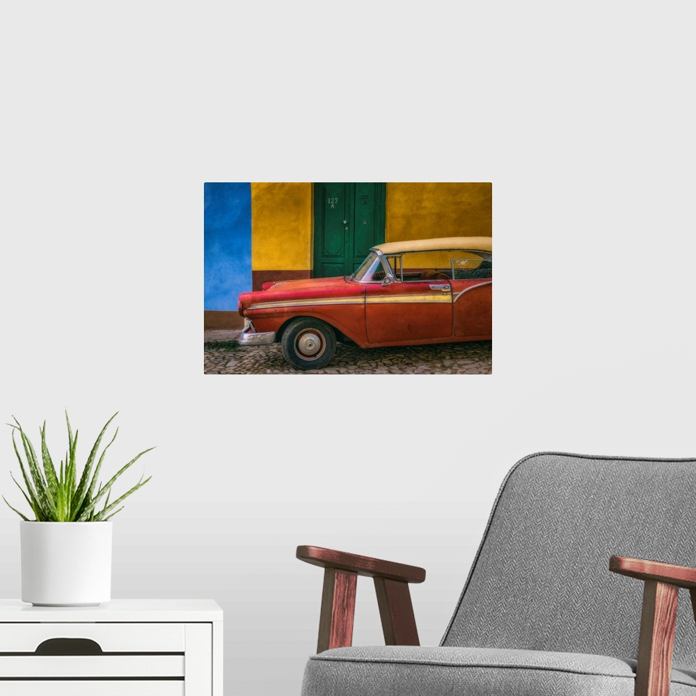 A modern room featuring A bright red vintage car parked against a yellow and blue wall with a green door in the streets o...