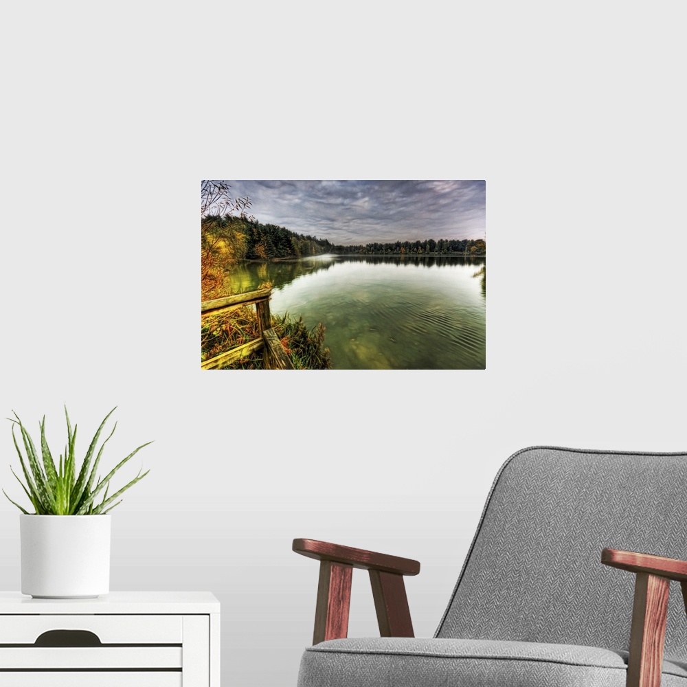 A modern room featuring View from a jetty across a misty foggy smooth boating lake with stormy dramatic skies and surroou...