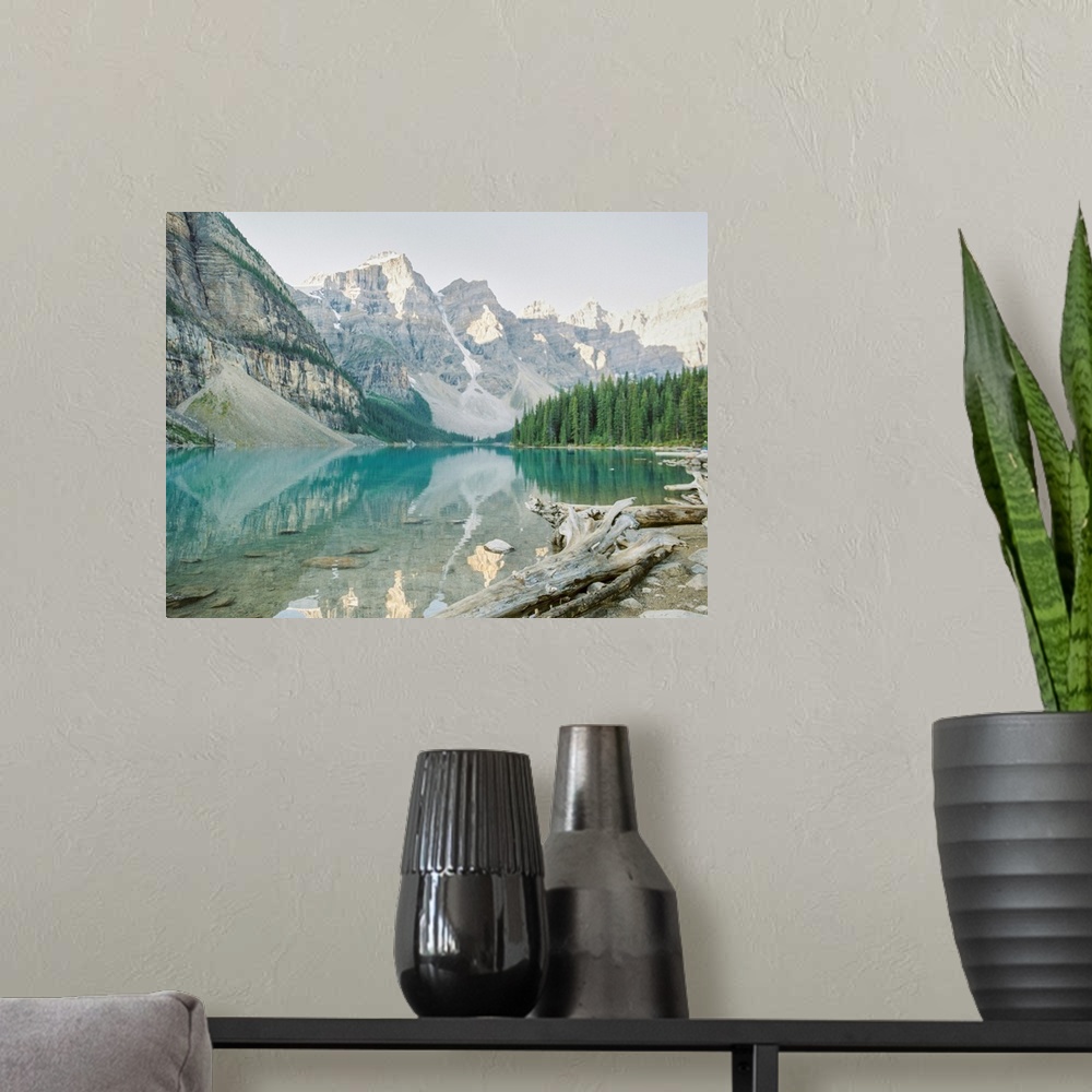 A modern room featuring A photograph of mountains reflecting in the clear blue water of Moraine Lake, Banff National Park...