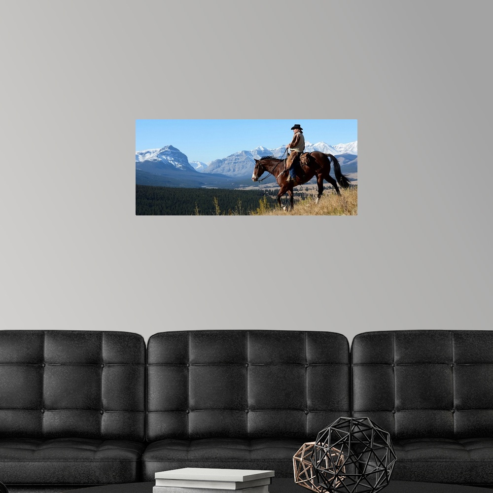 A modern room featuring Cowboy riding with a view of the Rocky mountains, Ya-Ha-Tinda Ranch, Clearwater County, Alberta, ...
