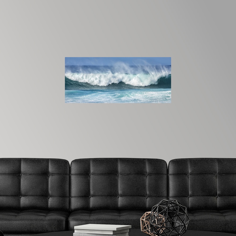 A modern room featuring Mist rising off crashing blue waves at the shore; Kihei, Maui, Hawaii, United States of America.