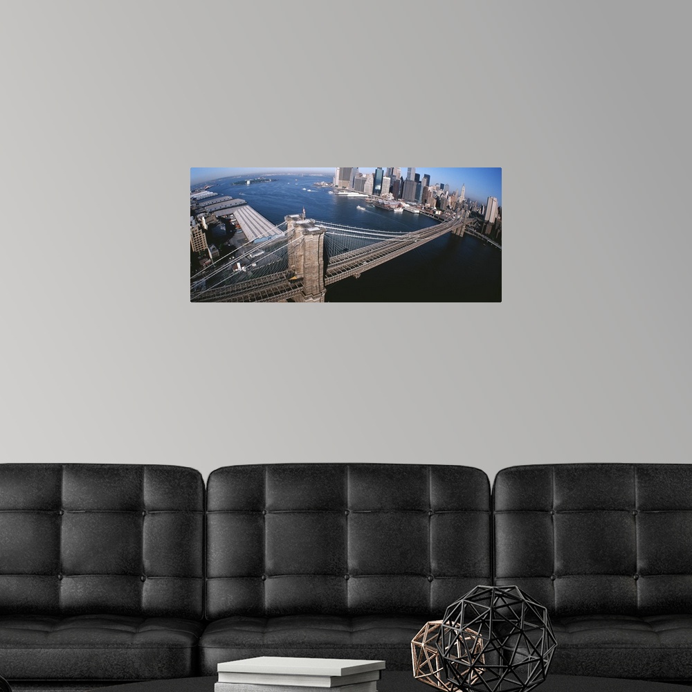 A modern room featuring Panorama of the Brooklyn Bridge, skyscrapers and boats in the East River of New York City.