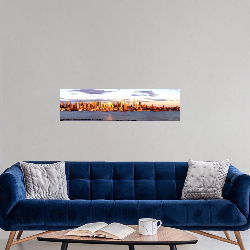 A modern room featuring Panoramic photograph of the distant Manhattan skyline at the waters edge, with golden skyscrapers...