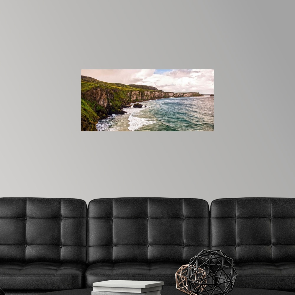 A modern room featuring Panoramic photograph of the picturesque Cliffs of Moher with a cloudy sky above, located at the s...