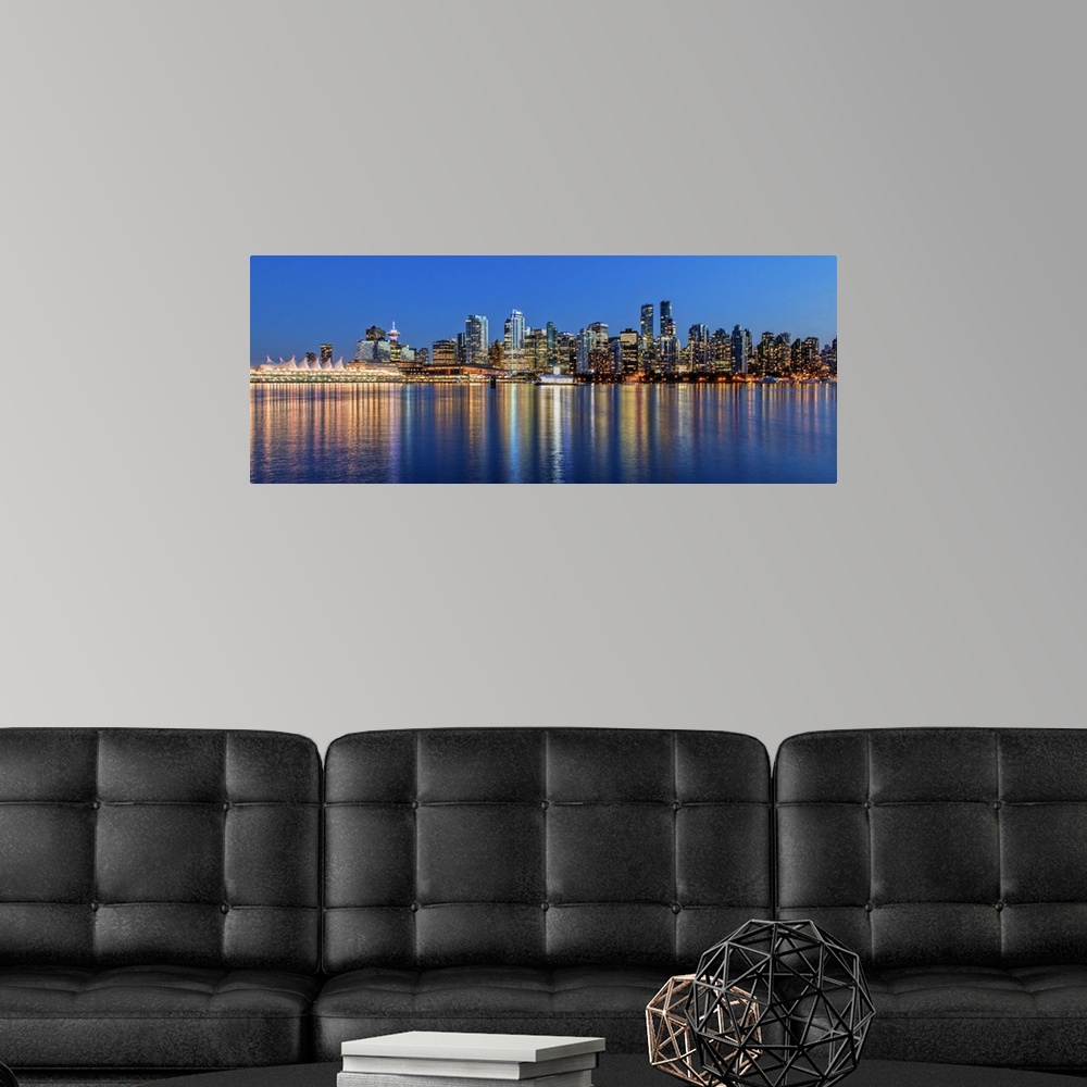 A modern room featuring Photograph of the downtown Vancouver skyline lit up at dusk and reflecting onto the water creatin...