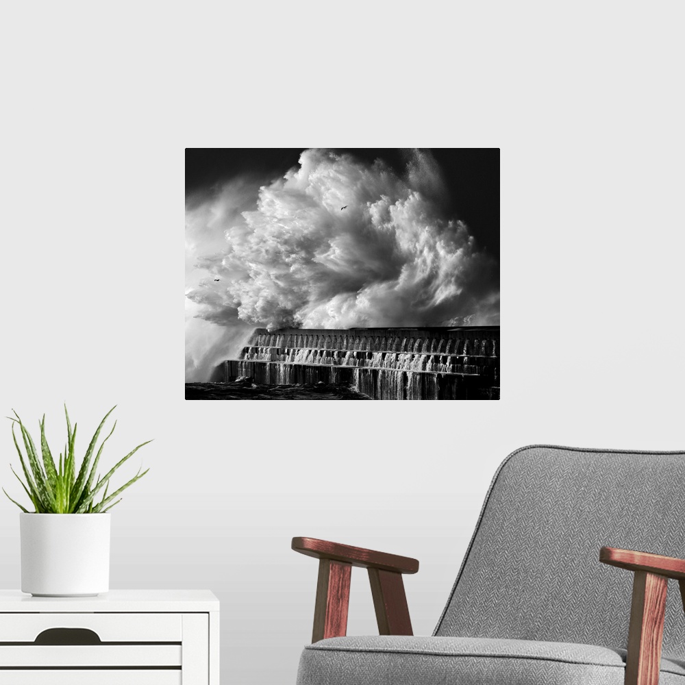 A modern room featuring A black and white photograph of a massive wave crashing over a pier.