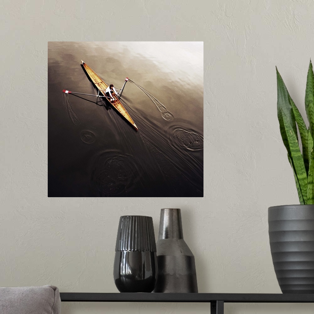 A modern room featuring A female athlete rowing on still, dark water, leaving a small wake.