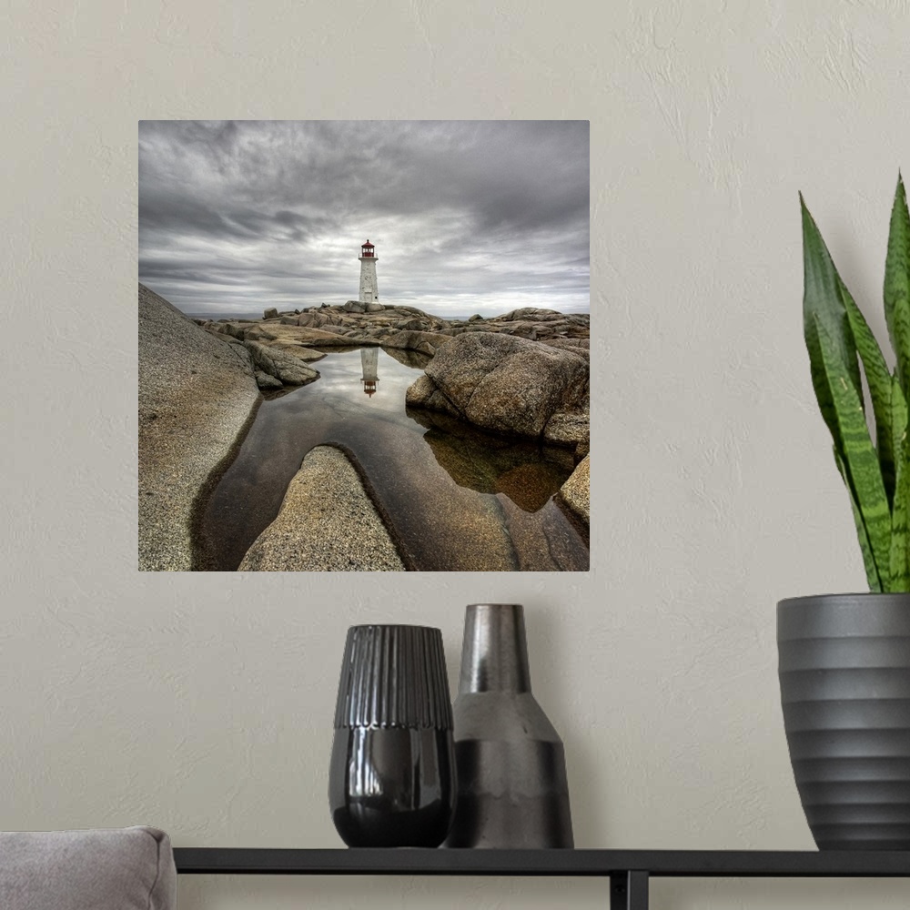 A modern room featuring A distant Canadian lighthouse casting its reflection in a rocky tidal pool in the foreground.