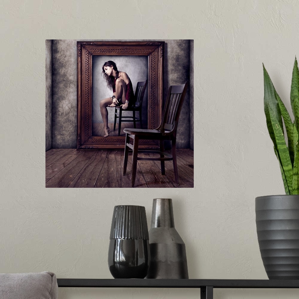 A modern room featuring Conceptual image of a woman sitting on a chair in a large picture frame, with an empty chair in t...
