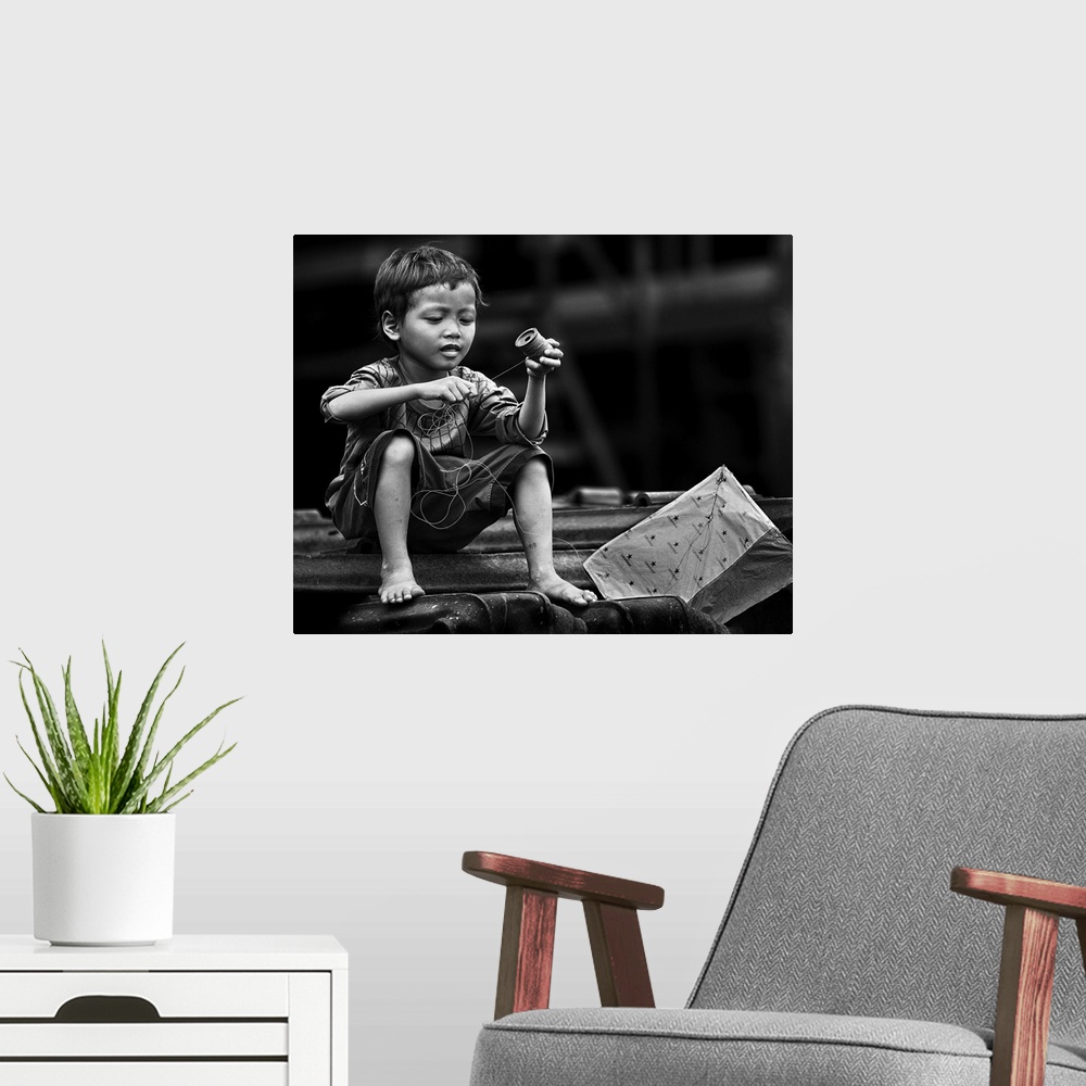 A modern room featuring Black and white image of a boy winding the string of his kite.
