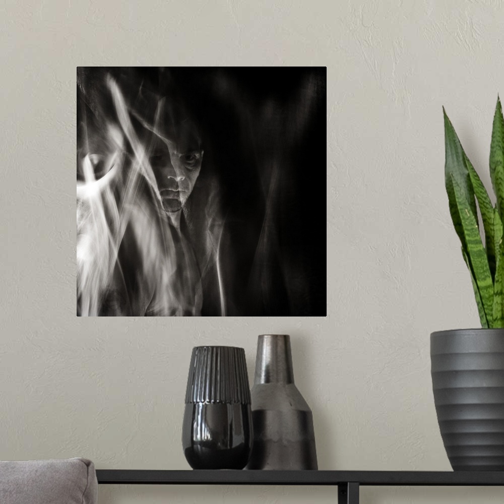 A modern room featuring Square black and white surreal photograph of a man's face in the background with abstract smoke a...