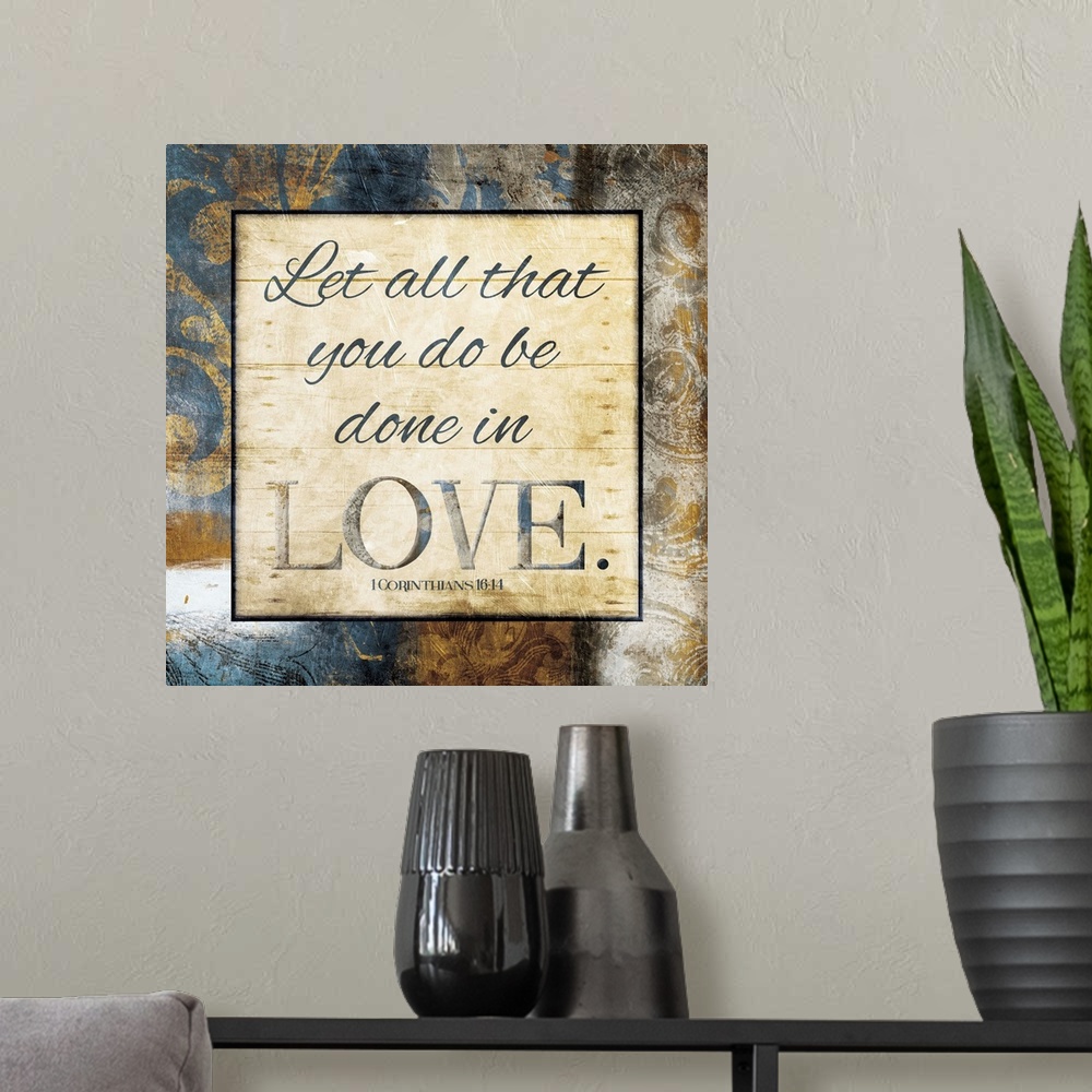 A modern room featuring Typography art of the Bible verse 1 Corinthians 16:14 framed with classic style gold and blue flo...
