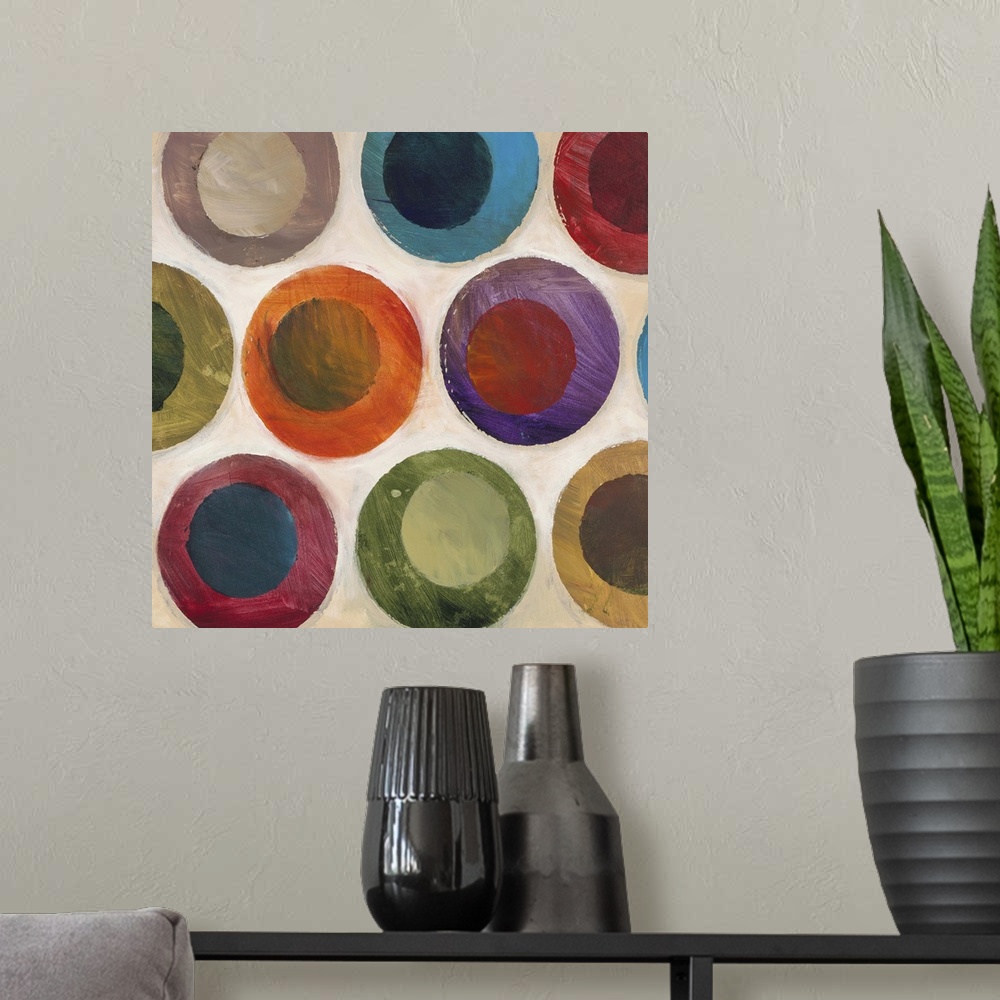 A modern room featuring Contemporary abstract painting of multi-colored circles against a beige background.
