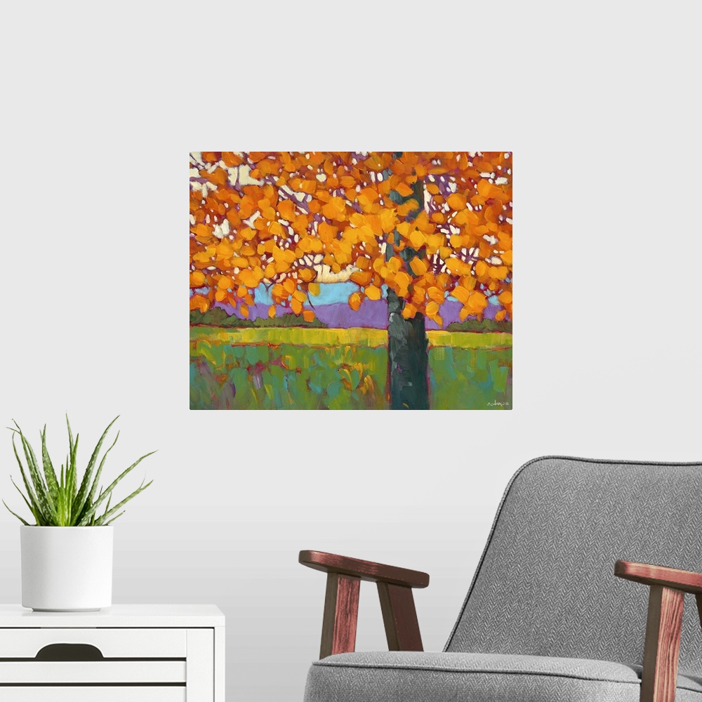 A modern room featuring A tree with bright orange leaves in the fall.