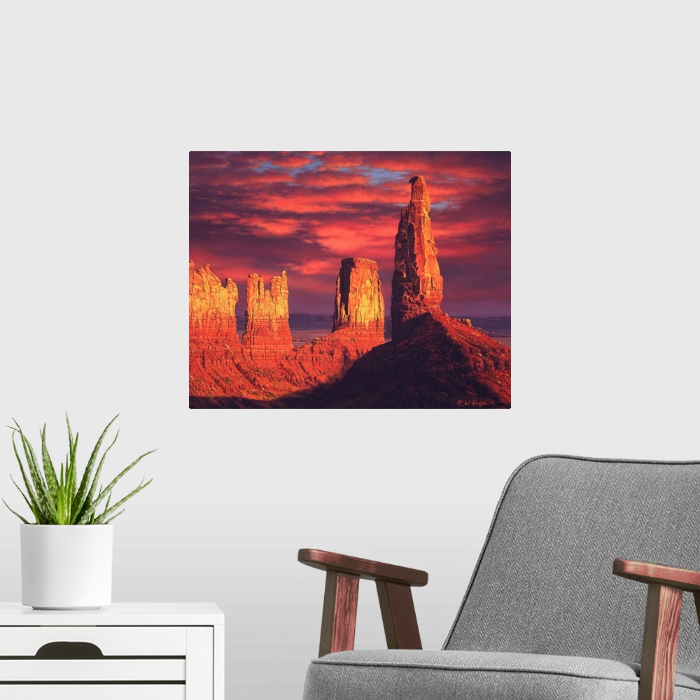A modern room featuring The sun setting on plateaus in Monument valley.