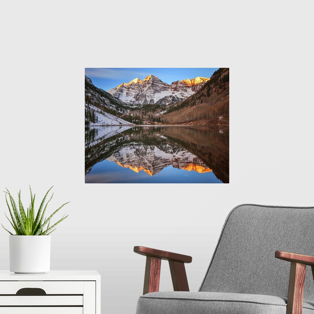 A modern room featuring Sunlight on the peaks of the Maroon Bells, reflected in the lake below.
