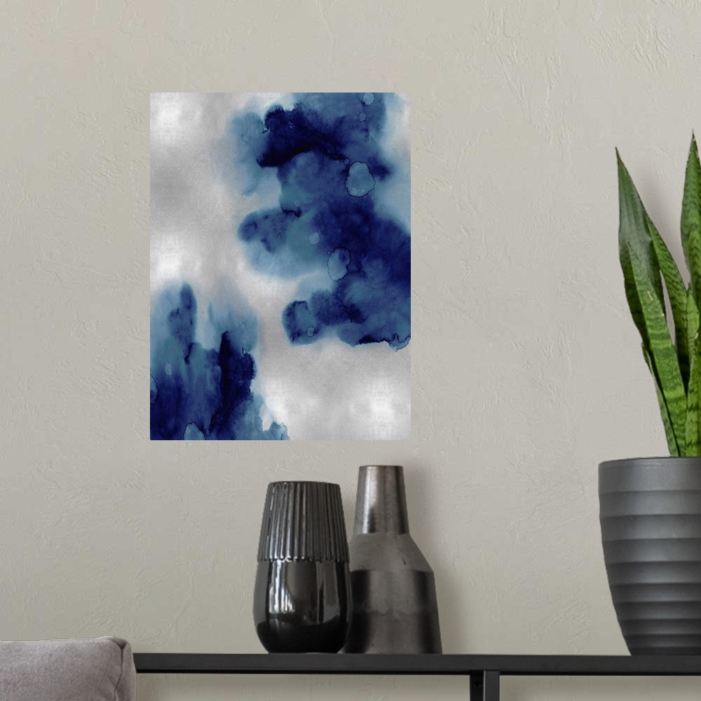 A modern room featuring Abstract painting with indigo hues splattered together on a silver background.