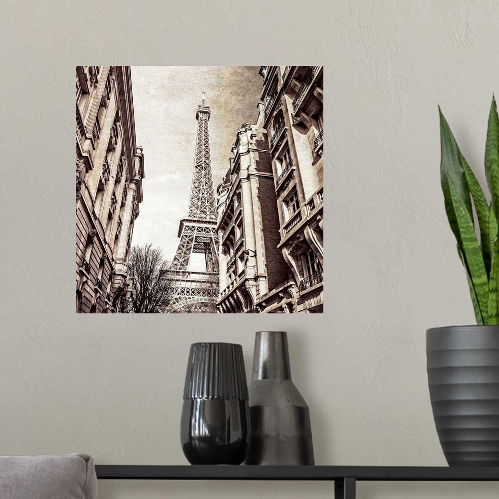 A modern room featuring A square photo of the Eiffel Tower from the street in a sepia tone and a textured effect overlay.