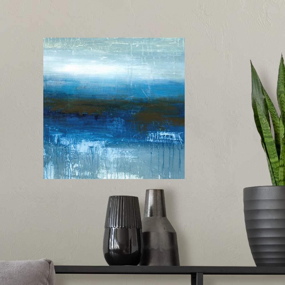 A modern room featuring Square abstract painting in textured colors of blue, white and gray.