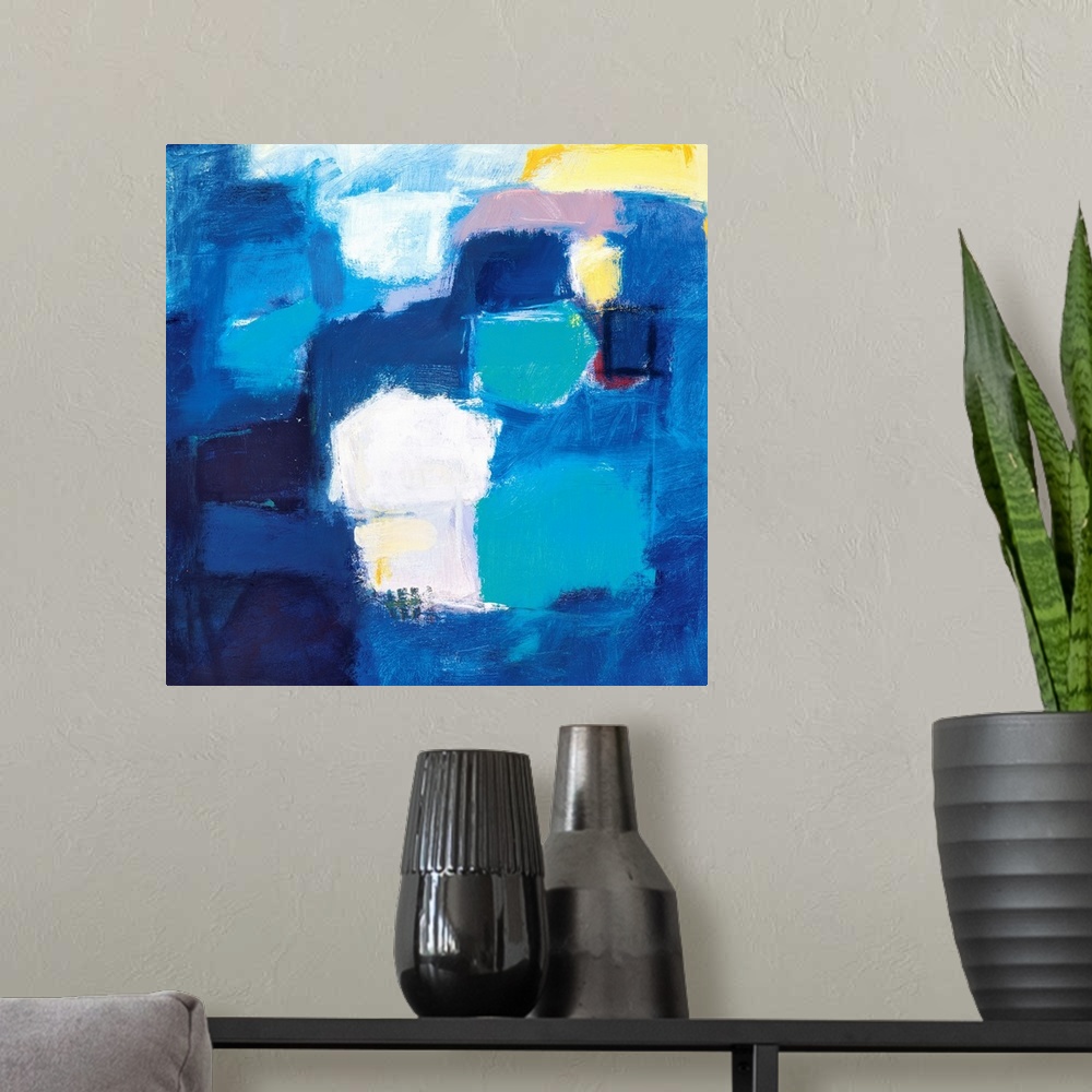 A modern room featuring A modern abstract painting of square style shapes in shades of blue with accent colors of yellow ...