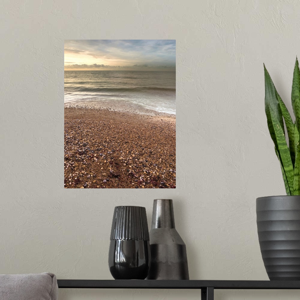 A modern room featuring Vertical photograph of a pebble covered beach with gentle waves.