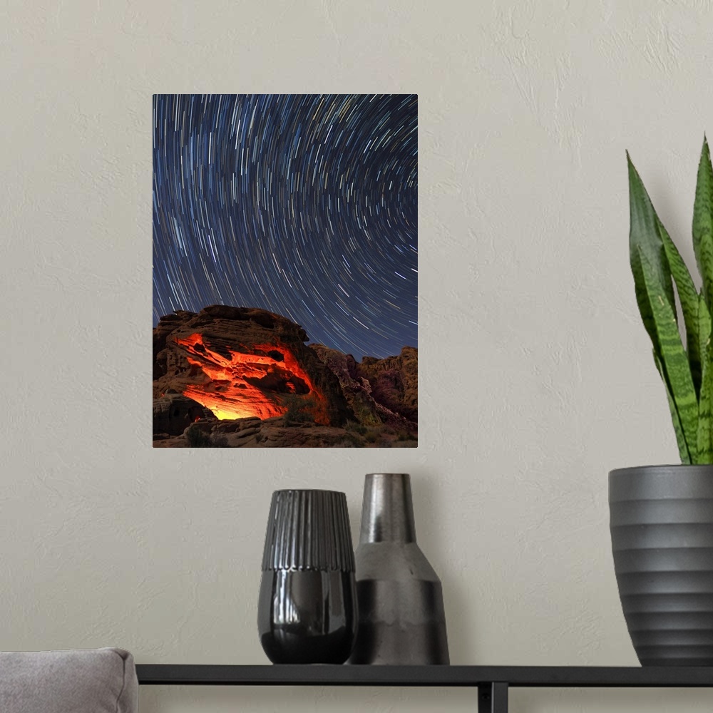 A modern room featuring Usa, Nevada. Valley of Fire State Park, star trails and campfire glowing in sandstone rocks.