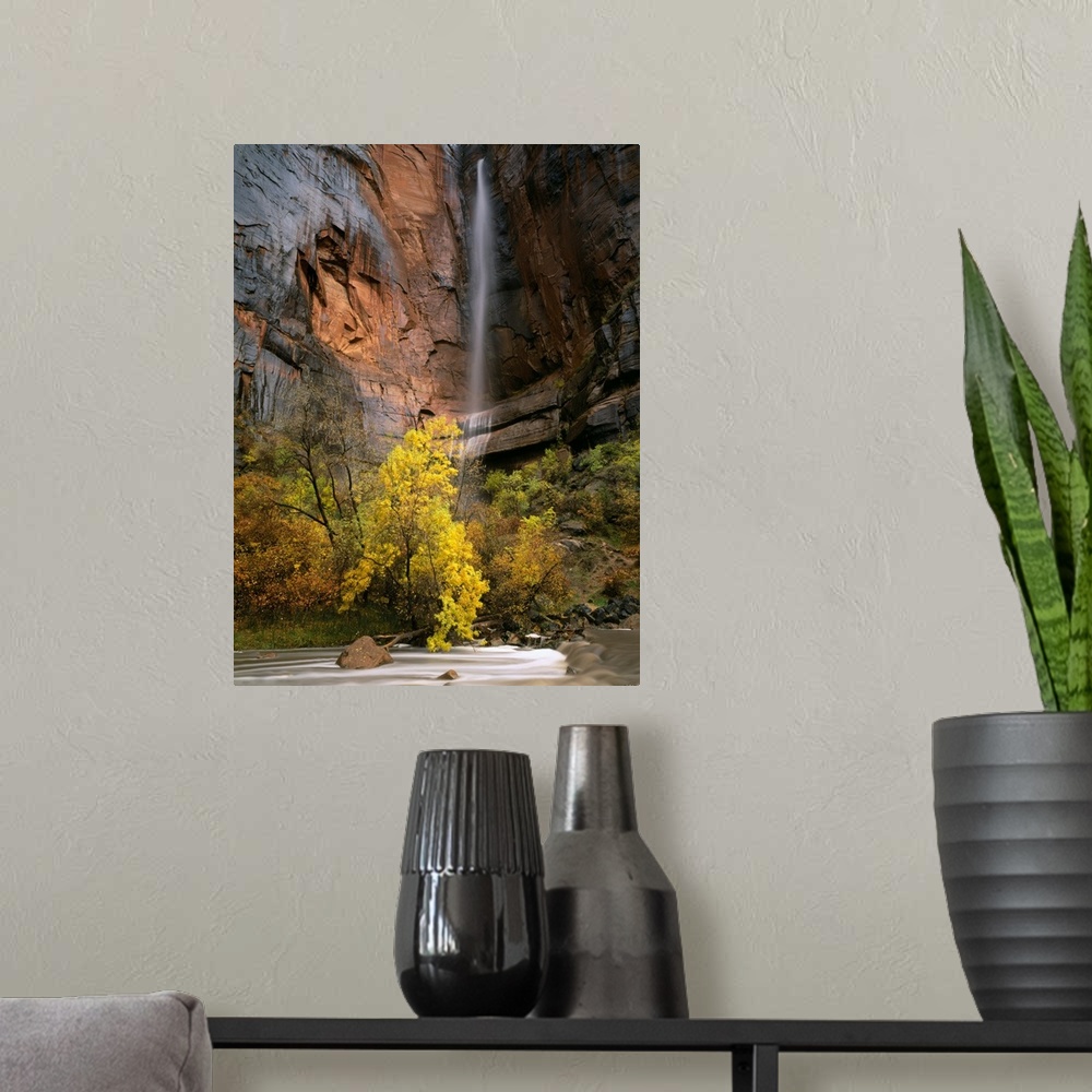 A modern room featuring Zion National Park, Utah. Ephemeral waterfall pours over cliff above Virgin River during autumn r...