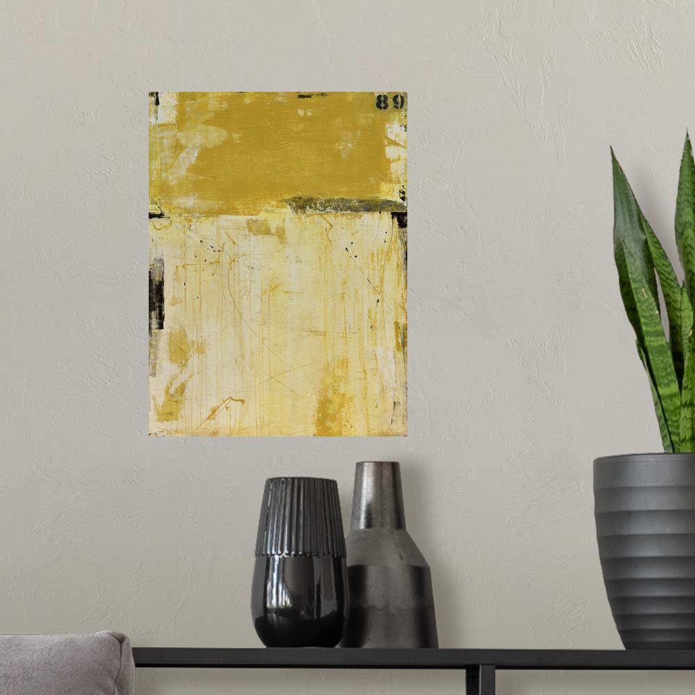 A modern room featuring A contemporary abstract painting using two tones of yellow meeting face to face.
