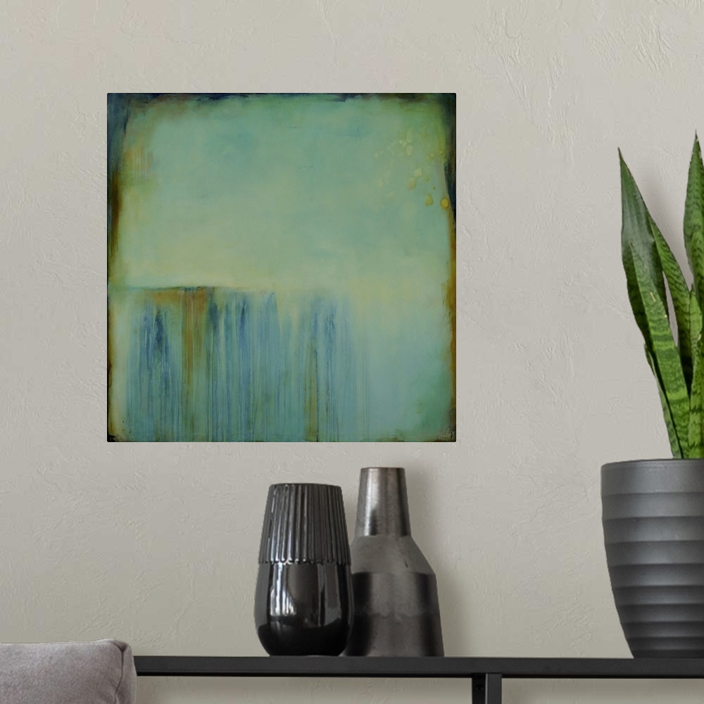 A modern room featuring Square abstract painting created with a muted blue turning into green with streaking lines in bro...