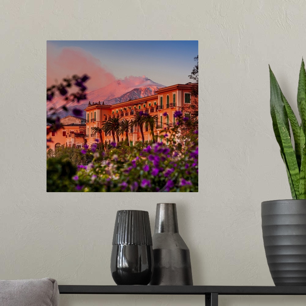 A modern room featuring Italy, Sicily, Messina district, Taormina, San Domenico Palace Hotel at sunset with Mount Etna in...