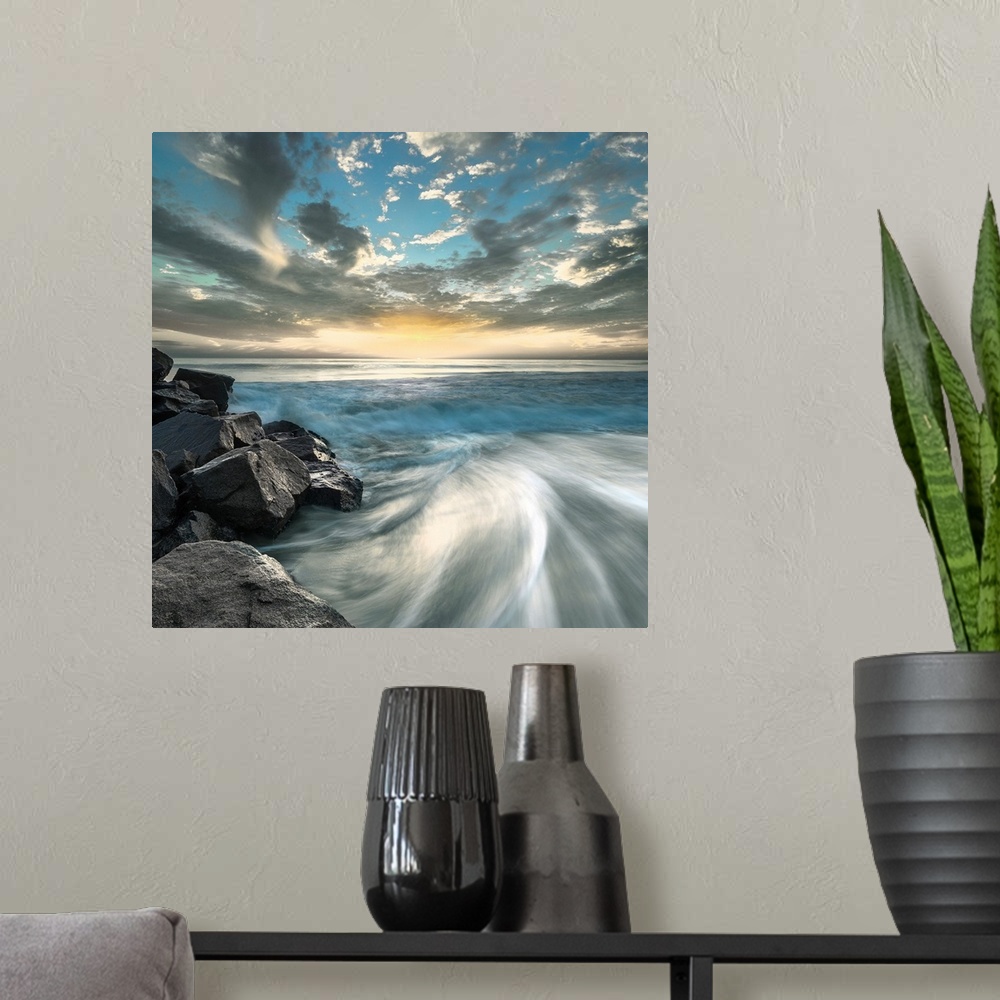 A modern room featuring Long exposure photograph of ocean waves crashing on a rocky beach shore with a dramatic sky.