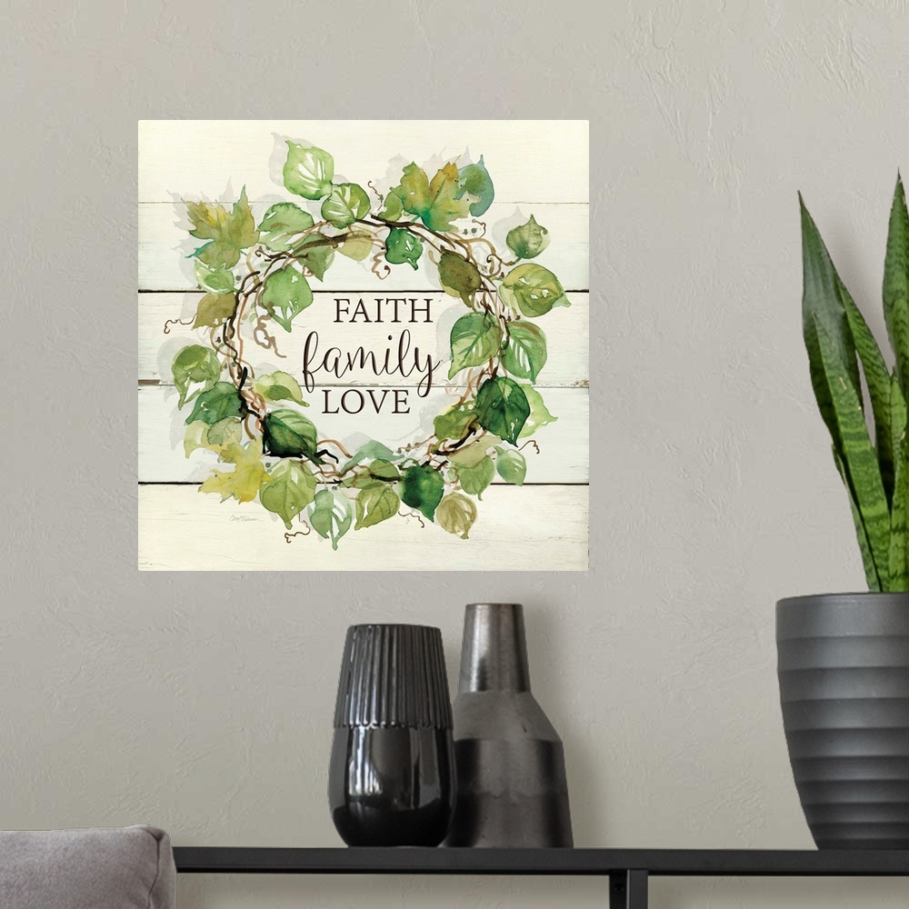 A modern room featuring A wreath of various watercolor leaves surround the words, "Faith, family, love" on shiplap.