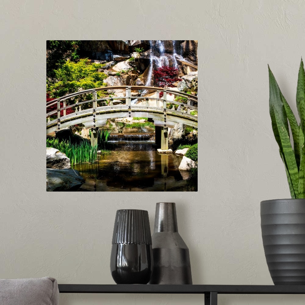 A modern room featuring Square photograph of a bridge over a stream with a waterfall in the background.