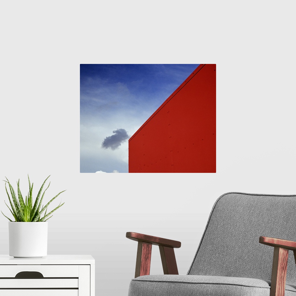 A modern room featuring A shadowed cloud floating through blue sky over the red corner of James John School.