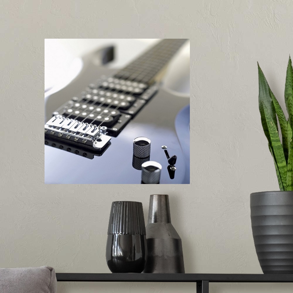 A modern room featuring Square photograph of a close-up of an electric guitar.