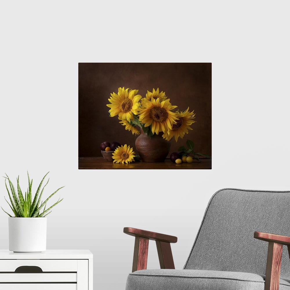 A modern room featuring Bouquet of sunflowers in old clay jug with ripe cherry plum branches in the foreground.