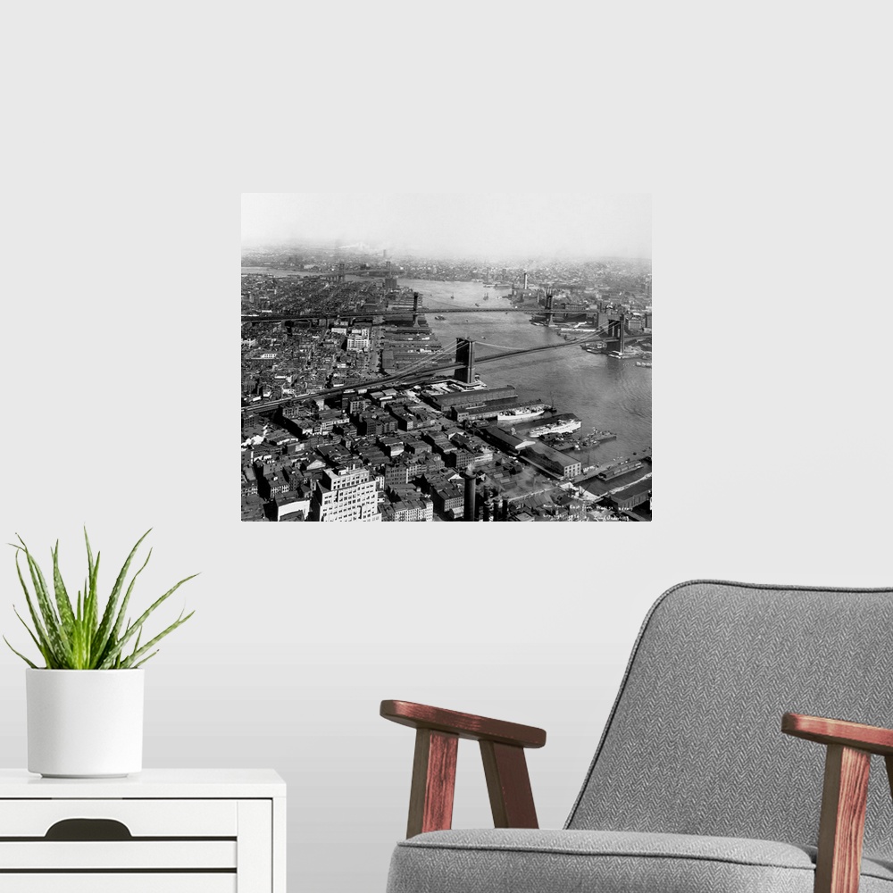 A modern room featuring A view up the East River with the Brooklyn, Manhattan and Williamsburg bridges as seen from Wall ...