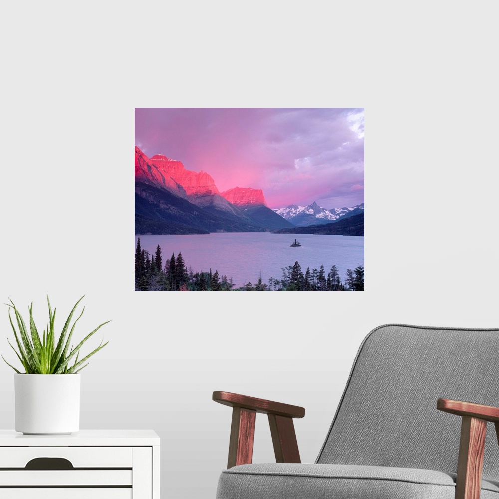 A modern room featuring Dawn sunlight illuminates the Rocky Mountains above Saint Mary Lake.