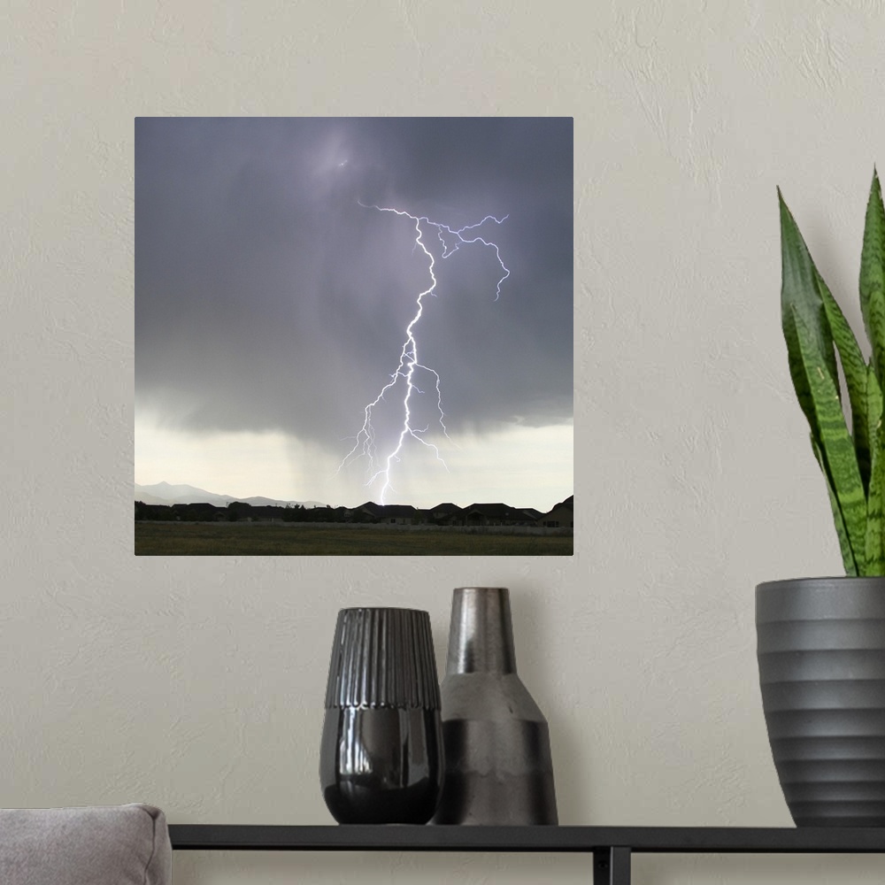 A modern room featuring Lightning strike sky over residential neighborhood.
