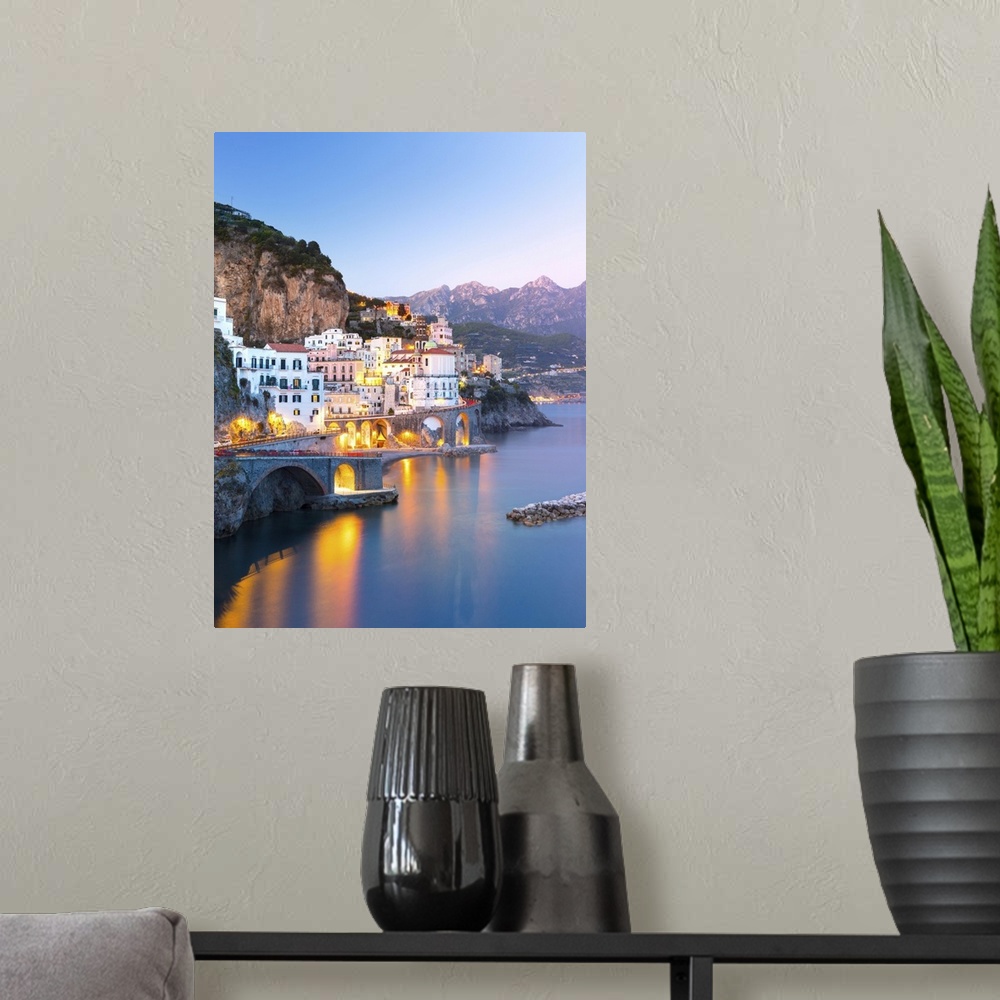 A modern room featuring Night view of Amalfi cityscape on coast line of Mediterranean sea, Italy.