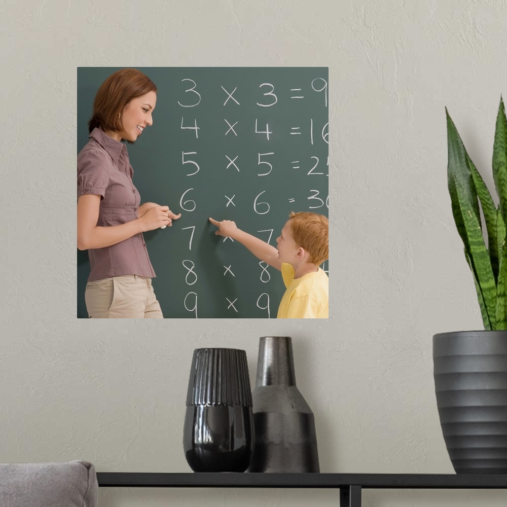 A modern room featuring Side profile of a female teacher teaching her student on a blackboard