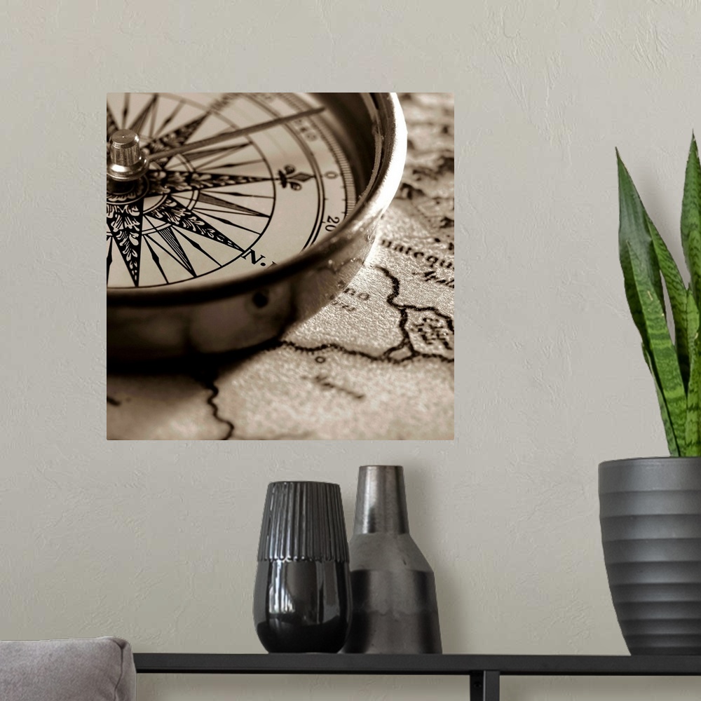 A modern room featuring Square close up photograph of a compass on a map in monochrome.