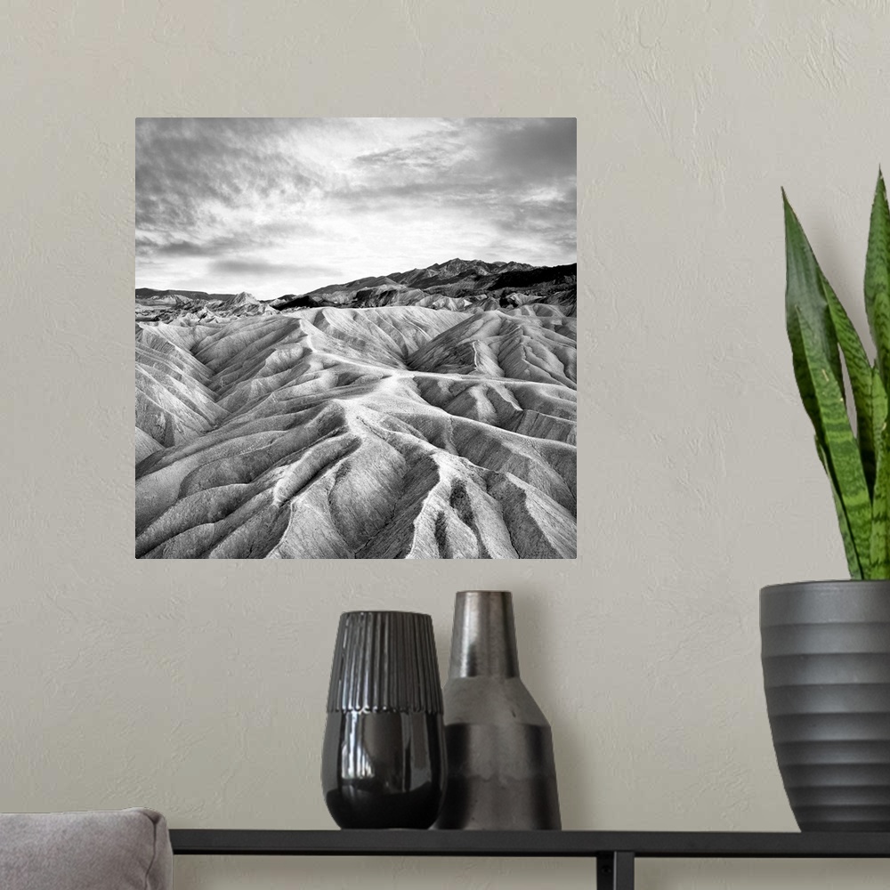 A modern room featuring Square black and white photograph of contrasting mountains ridges.
