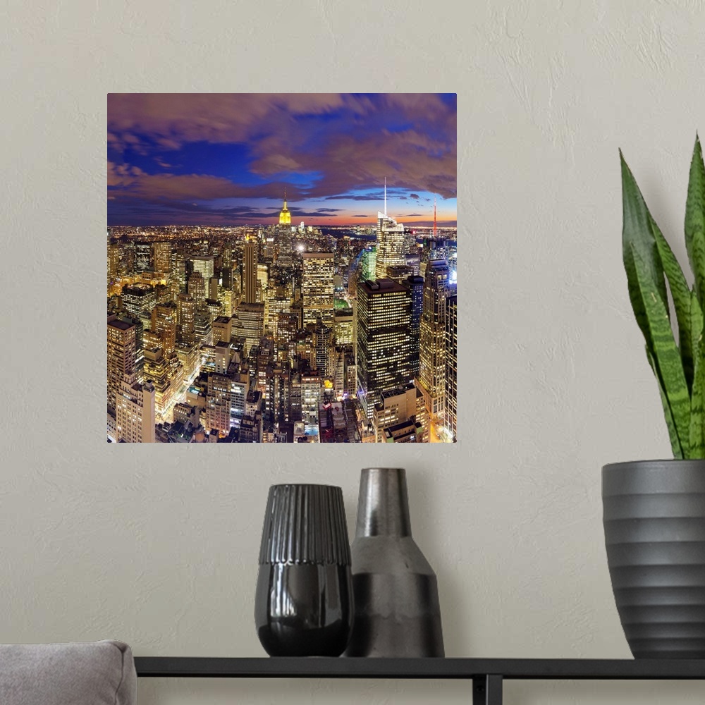A modern room featuring Manhattan view towards Empire State Building at sunset from Top of the Rock, at Rockefeller Plaza...