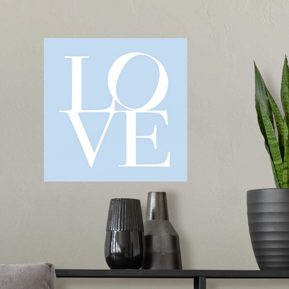 A modern room featuring LOVE, typography text art print and canvas print, with the word LOVE written against a baby blue ...