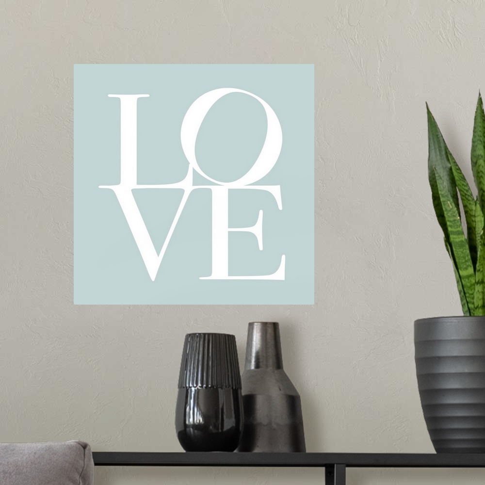 A modern room featuring LOVE, typography text art print and canvas print, with the word LOVE written against a duck egg b...
